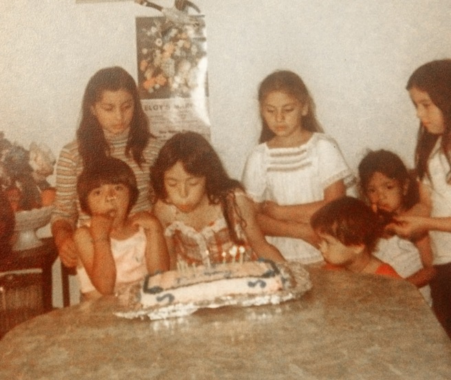 Herlinda at my sister, Corina's birthday party. Corina is blowing out the candles, Sandra is to her right and Herlinda is to her left in the white blouse with her arms crossed. Photo courtesy Sandra Gonzalez. 
